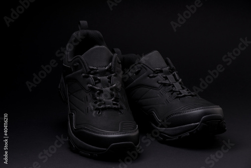 a pair of black sneakers on a dark background