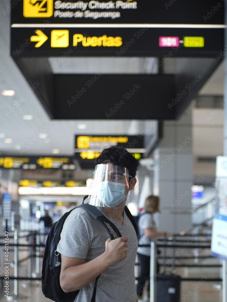 young man with mask and face mask at the airport terminal virus protection mask new normal tourist young man with mask and face mask at the airport terminal virus protection mask new normal tourist