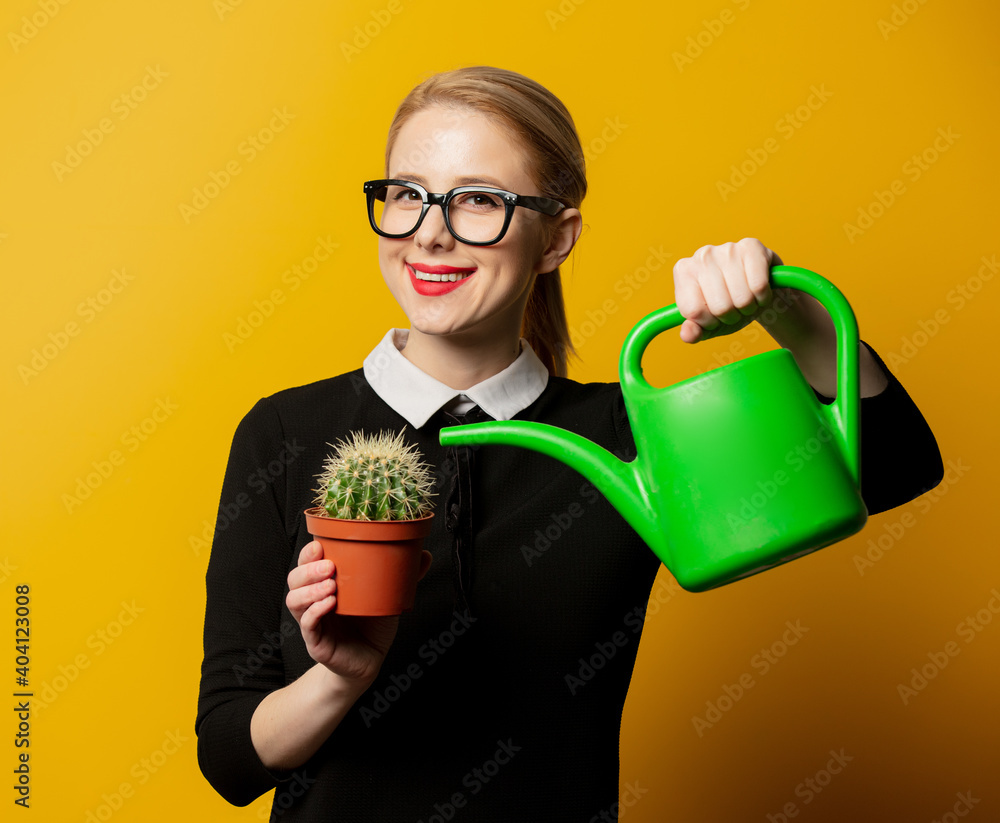 girl watering a cactus on a yellow background