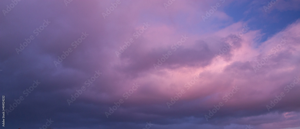 Natural color dramatic dawn or dusk sky with painterly yellow, pink and blue clouds with horizon, taken with wide angle 35 mm lens for sky replacement