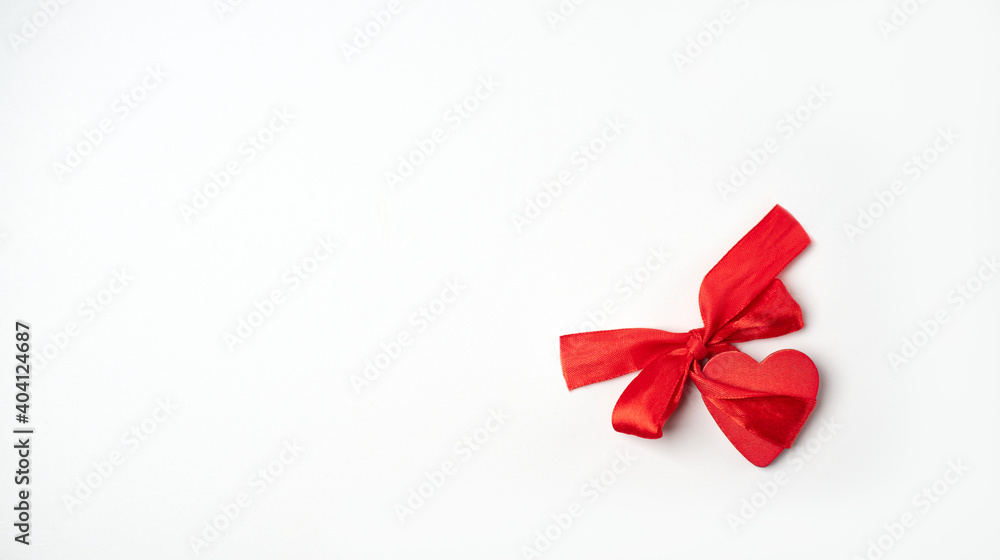 Red wooden heart with red bow-knot on the light (white) background. Valentine's Day concept. Flat lay, top view, space for text. Red wooden heart with red bow-knot on the light (white) background. Valentine's Day concept. Flat lay, top view, space for text.