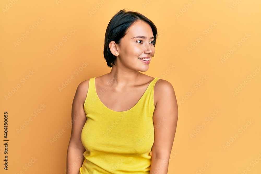 Beautiful young woman with short hair wearing casual clothes looking to side, relax profile pose with natural face and confident smile. Beautiful young woman with short hair wearing casual clothes looking to side, relax profile pose with natural face and confident smile.