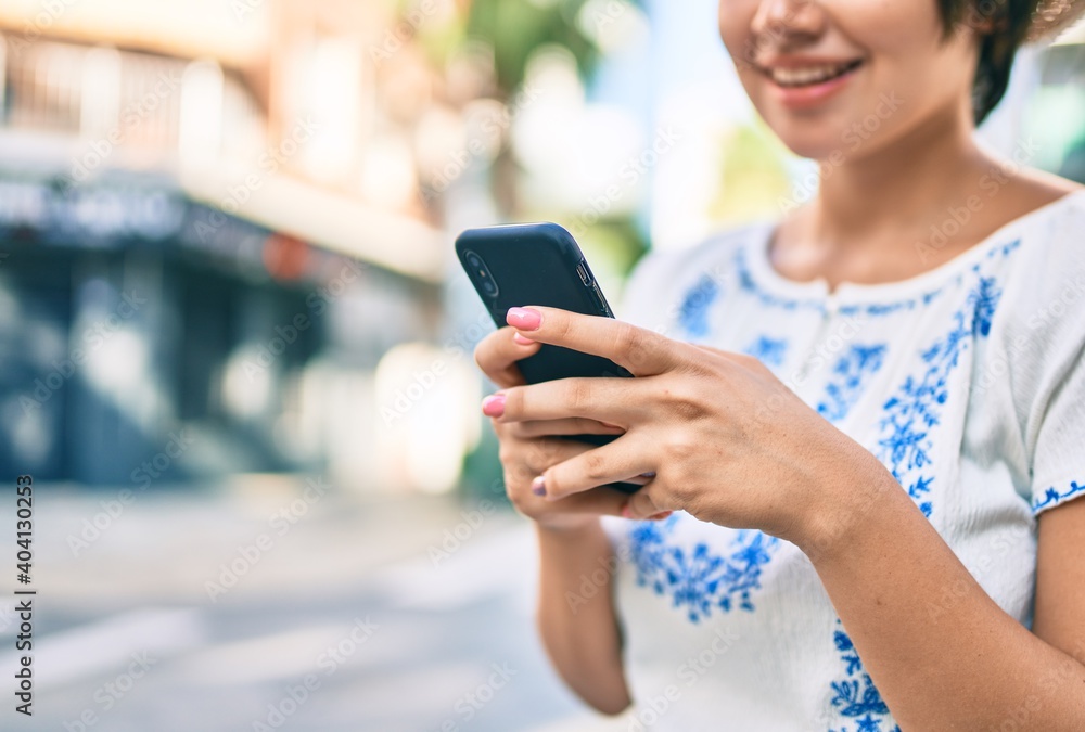 Young latin tourist girl on vacation smiling happy using smartphone at the city. Young latin tourist girl on vacation smiling happy using smartphone at the city.