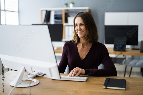 Woman In Office Using Business Computer