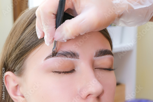 Quadro su tela Beautiful young woman got correction of eyebrows in a beauty salon