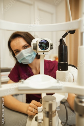 Optometrist slit lamp, ophtalmology diopters calibration in oculist lab of young woman doctor.
