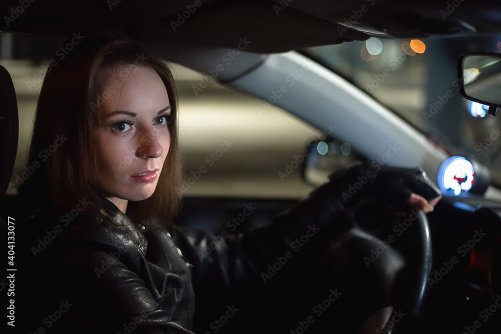 Fototapeta premium Young girl a driver by the car steering wheel.