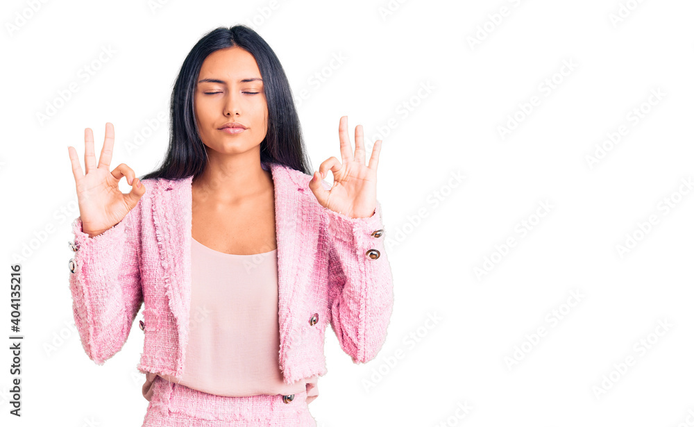 Young beautiful latin girl wearing business clothes relaxed and smiling with eyes closed doing meditation gesture with fingers. yoga concept. Young beautiful latin girl wearing business clothes relaxed and smiling with eyes closed doing meditation gesture with fingers. yoga concept.
