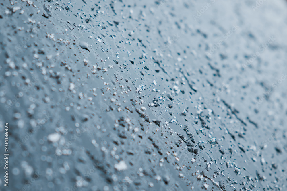 Melting snow and water drops on glass surface. Abstract blue tone background. Selective focus. Melting snow and water drops on glass surface. Abstract blue tone background. Selective focus.