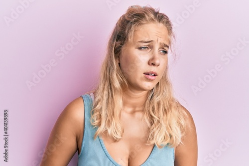 Young blonde girl wearing casual clothes with hand on stomach because nausea  painful disease feeling unwell. ache concept.