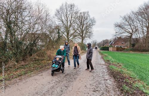 Multi-generational family walking on footpath between fields