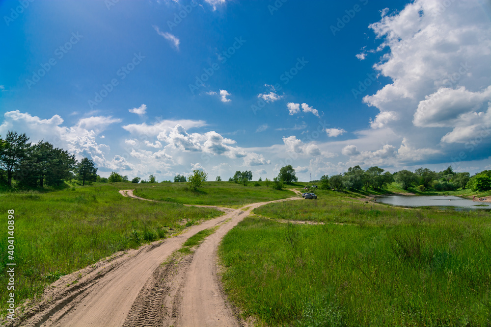 road in the field and clouds in the summer