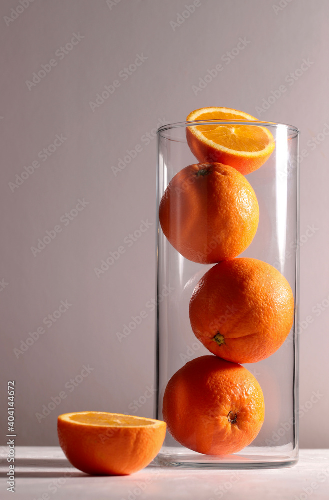 Arance fresche in un vaso di vetro su sfondo grigio. Copia spazio. Stock  Photo