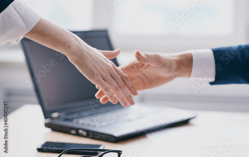 Handshake gesturing hands laptop office work window room