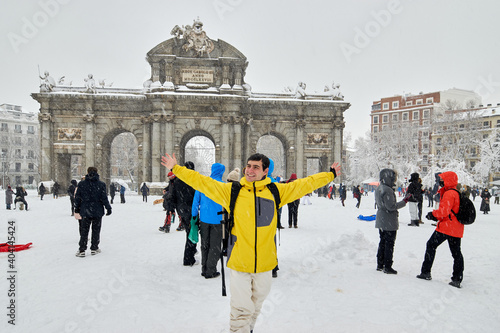 Young male smiling under snow, winter in madrid