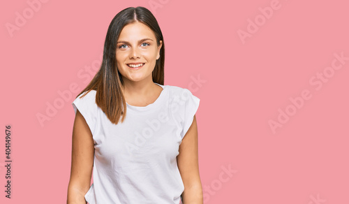 Young caucasian woman wearing casual white tshirt with a happy and cool smile on face. lucky person.
