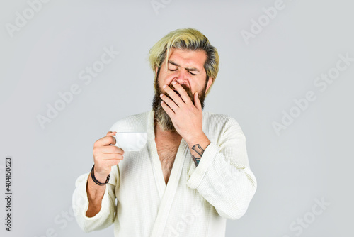 Morning begins with coffee. Understanding Your Daily Rhythms. Bearded man with mug. Breakfast concept. Man with beard in bathrobe enjoy morning coffee. Guy in domestic clothes hold coffee cup