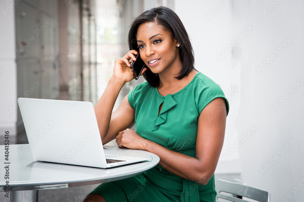 African American woman in green dress in modern corporate building lobby African American woman in green dress in modern corporate building lobby