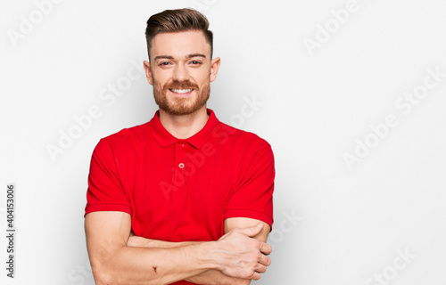 Young redhead man wearing casual clothes happy face smiling with crossed arms looking at the camera. positive person.