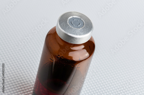 Macro Image Of Amber Vaccine Vial Set On Metal Background photo