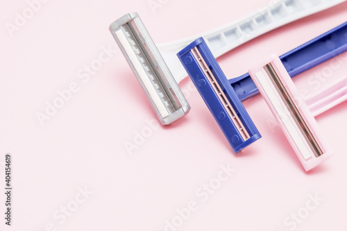 Disposable plastic razor blades for everyday morning routine and shaving unwanted hair on face, legs and armpits, grooming concept on pink background
