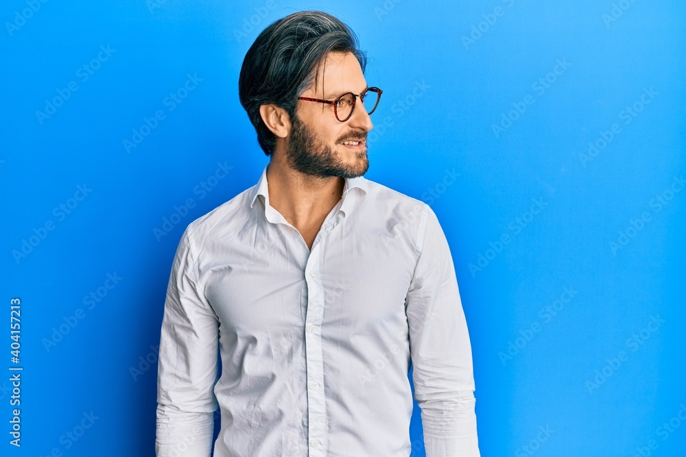 Young hispanic man wearing casual clothes and glasses looking to side, relax profile pose with natural face and confident smile. Young hispanic man wearing casual clothes and glasses looking to side, relax profile pose with natural face and confident smile.