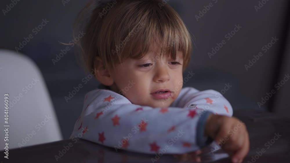 Bashful little baby boy pointing finger at laptop screen watching content Bashful little baby boy pointing finger at laptop screen watching content