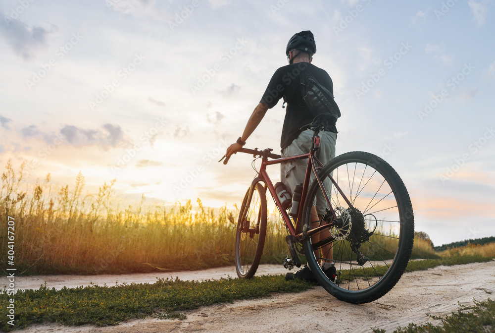 Cyclist in the field enjoying the sunset after sport training. Cyclist in the field enjoying the sunset after sport training.