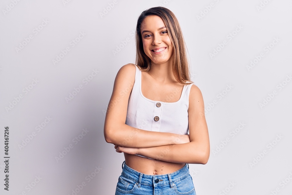 Young beautiful girl wearing casual sleveeless t-shirt happy face smiling with crossed arms looking at the camera. positive person. Young beautiful girl wearing casual sleveeless t-shirt happy face smiling with crossed arms looking at the camera. positive person.