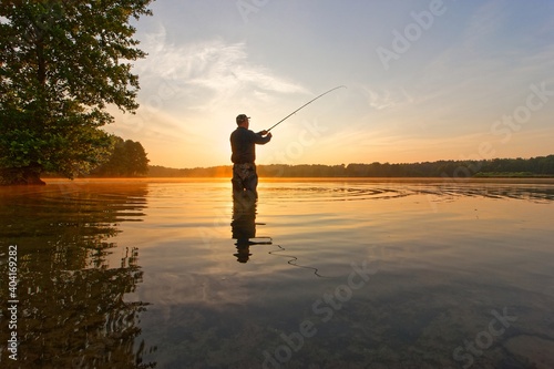 angler catching the fish during summer sunrise