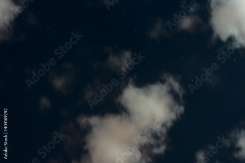 Low light night skyscape. Cloud and stars in dark blue sky.