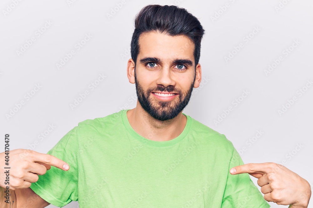 Young handsome man with beard wearing casual t-shirt looking confident with smile on face, pointing oneself with fingers proud and happy. Young handsome man with beard wearing casual t-shirt looking confident with smile on face, pointing oneself with fingers proud and happy.