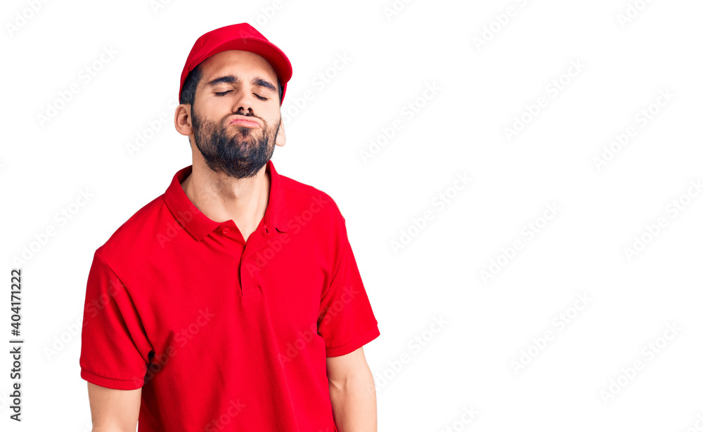 Young handsome man with beard wearing delivery uniform looking at the camera blowing a kiss on air being lovely and sexy. love expression. Young handsome man with beard wearing delivery uniform looking at the camera blowing a kiss on air being lovely and sexy. love expression.