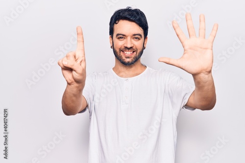 Young hispanic man wearing casual clothes showing and pointing up with fingers number six while smiling confident and happy.
