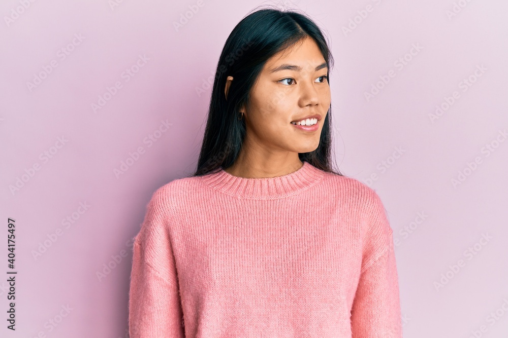 Young chinese woman wearing casual clothes looking to side, relax profile pose with natural face and confident smile. Young chinese woman wearing casual clothes looking to side, relax profile pose with natural face and confident smile.
