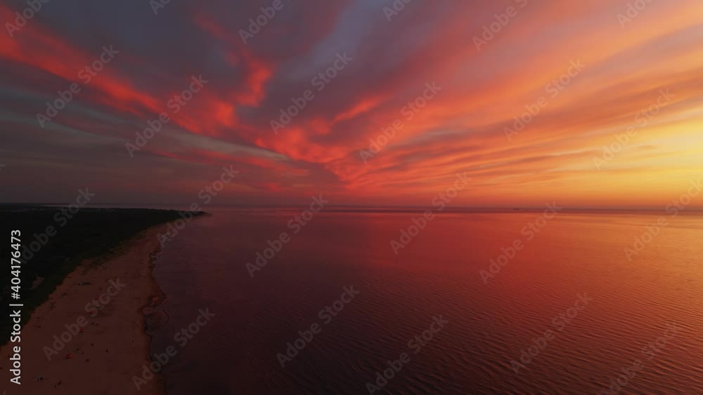 Aerial scenic sunset: Unreal view over rare red and orange sky above beautiful reflecting sea and beach Aerial scenic sunset: Unreal view over rare red and orange sky above beautiful reflecting sea and beach