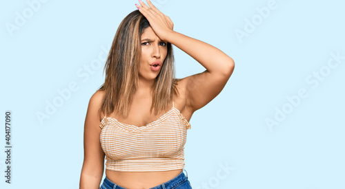 Beautiful brunette woman wearing casual clothes surprised with hand on head for mistake, remember error. forgot, bad memory concept.