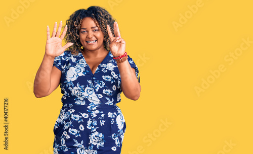Young african american plus size woman wearing casual clothes showing and pointing up with fingers number eight while smiling confident and happy. © Krakenimages.com