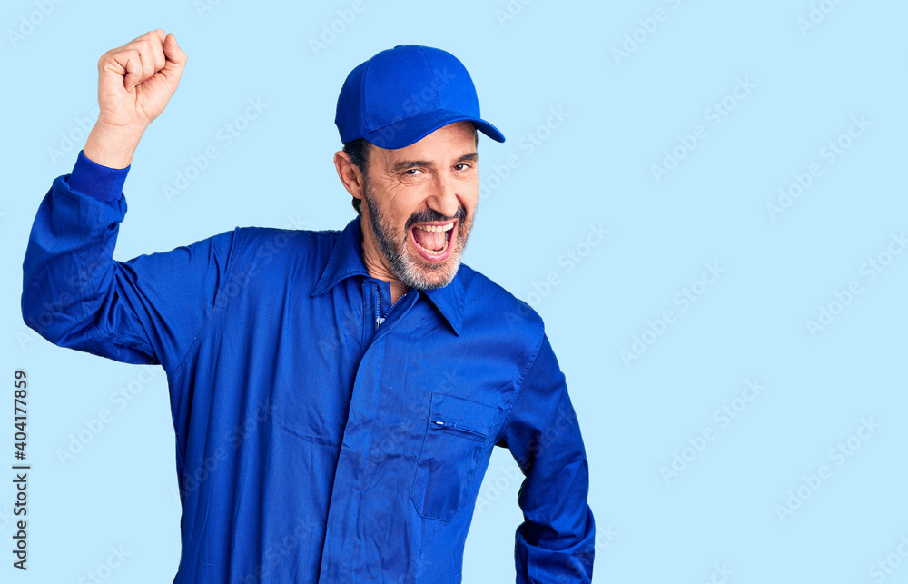 Middle age handsome man wearing mechanic uniform dancing happy and cheerful, smiling moving casual and confident listening to music