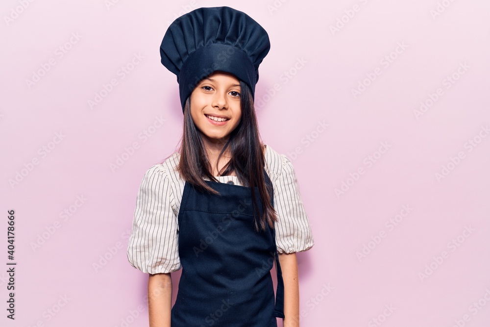 Beautiful child girl wearing cooker uniform with a happy and cool smile on face. lucky person. Beautiful child girl wearing cooker uniform with a happy and cool smile on face. lucky person.