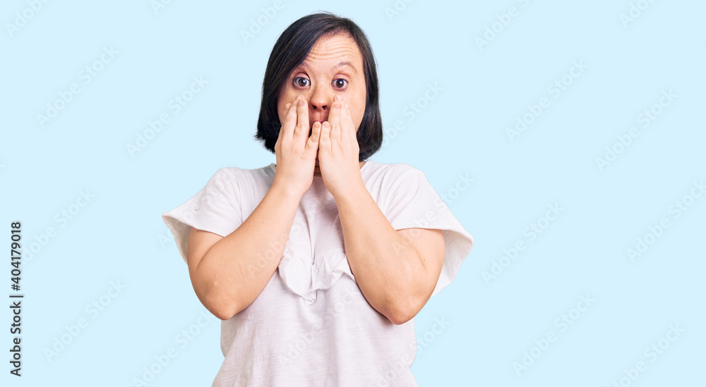 Brunette woman with down syndrome wearing casual white tshirt afraid and shocked, surprise and amazed expression with hands on face Brunette woman with down syndrome wearing casual white tshirt afraid and shocked, surprise and amazed expression with hands on face