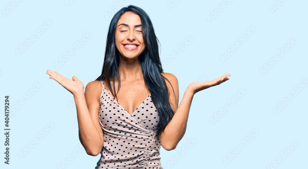 Beautiful hispanic woman wearing summer dress celebrating mad and crazy for success with arms raised and closed eyes screaming excited. winner concept Beautiful hispanic woman wearing summer dress celebrating mad and crazy for success with arms raised and closed eyes screaming excited. winner concept