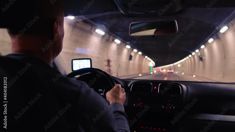 car driver driving through a long, lamp-lit tunnel in the Swiss mountains, selective focus on the vehicle dashboard, auto travel concept, road traffic, positive exit car driver driving through a long, lamp-lit tunnel in the Swiss mountains, selective focus on the vehicle dashboard, auto travel concept, road traffic, positive exit