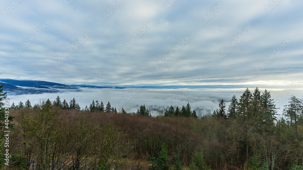 Cloudy sky over mist-covered BC valley viewed from mountain residence