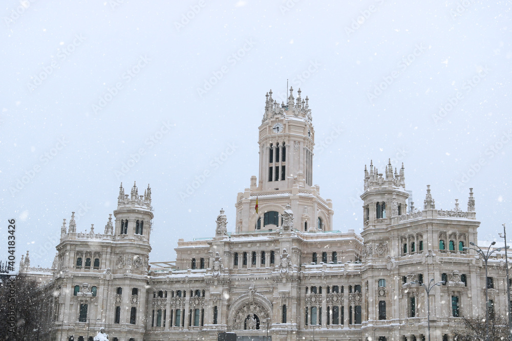 Madrid center with the monument of the city hall in the background while snowing - winter postcard from Spain