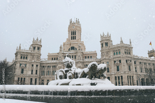 Madrid city center with the Cibeles monument and the city hall palace covered in snow - Postcard from Spain in winter