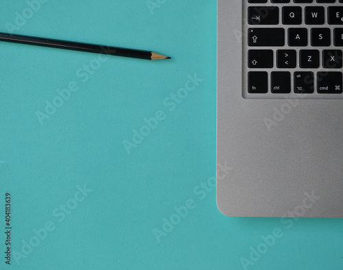 notebook and pencil on a turquoise desk