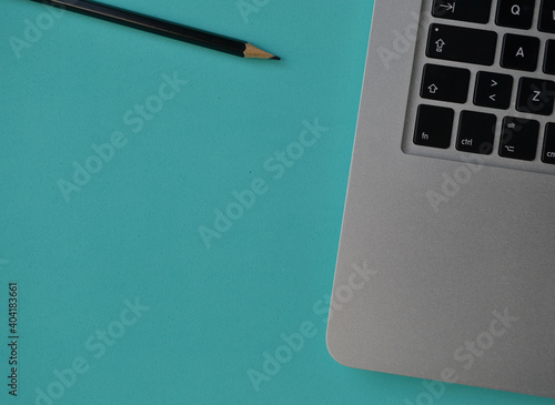 notebook and pencil on a turquoise desk