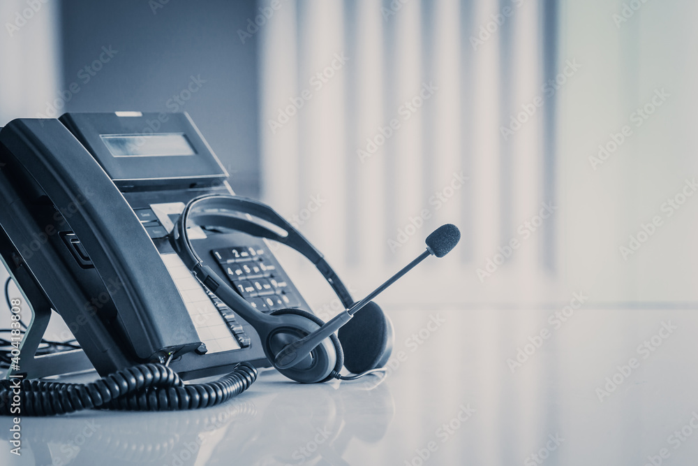 Communication support, call center and customer service help desk. VOIP headset on telephone keyboard. Communication support, call center and customer service help desk. VOIP headset on telephone keyboard.