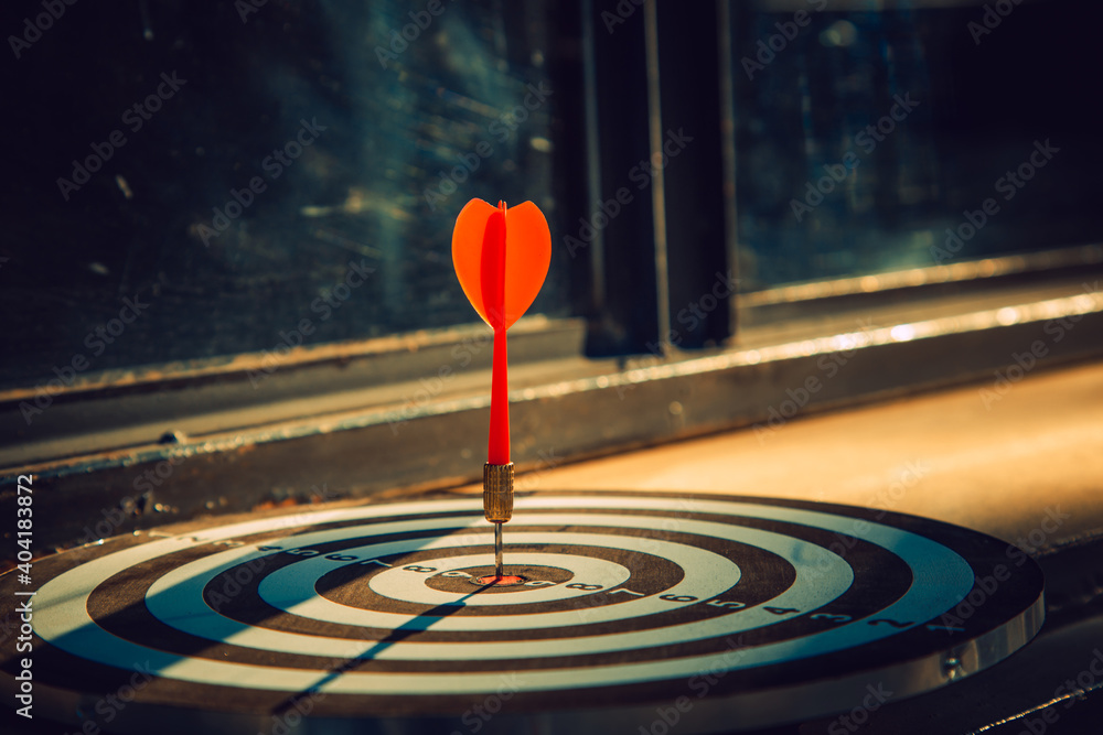 Dart arrow hit on bulleyes of dartboard to represent that the business reached the target with dark tone picture style. Target and goal as concept. Dart arrow hit on bulleyes of dartboard to represent that the business reached the target with dark tone picture style. Target and goal as concept.